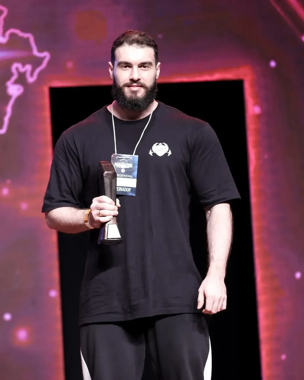 Rodrigo Capello segurando um troféu no palco de um campeonato